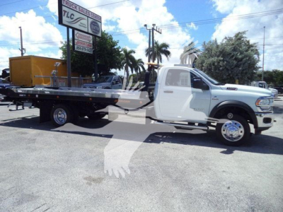 Truck showing a white Ram 5500 SLT rollback w/ flatbed in a dealership lot
