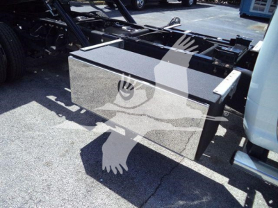 Storage toolbox mounted on truck frame with black textured lid and metal box, visible undercab area and chassis.