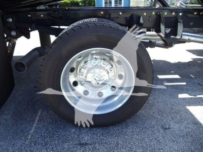 Wheel and suspension components of a Ram 5500 chassis showing a steel wheel and tire attached to a truck frame.