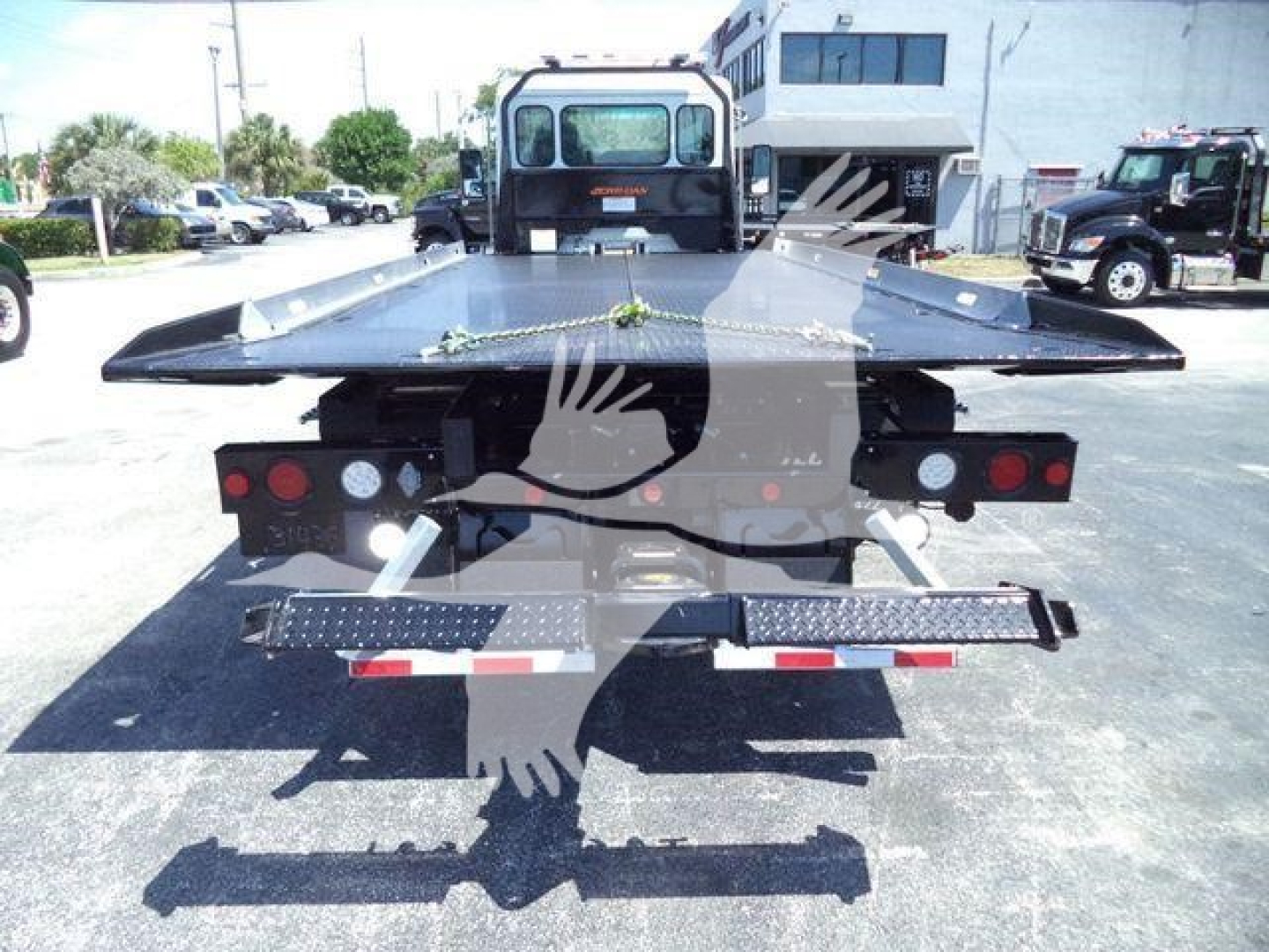 Kenworth T280 rollback truck rear view showing hydraulic bed and taillights with platform deployed