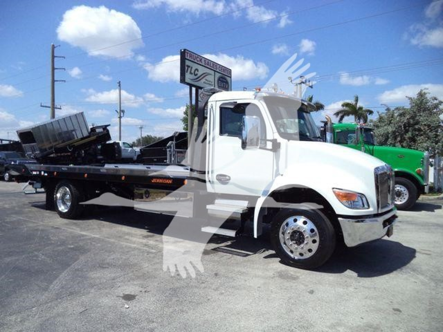 Kenworth T280 rollback tow truck in white cab with flatbed, side view showing wheel and dual rear axles.