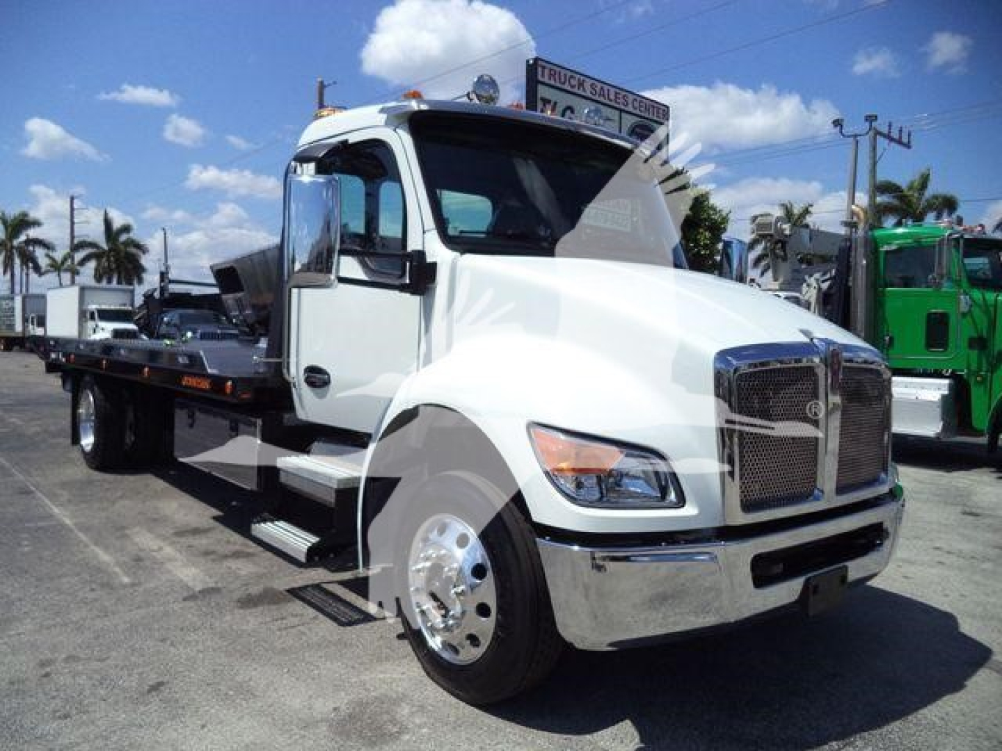 Kenworth T280 rollback truck in white showing side view with front chrome grille and flatbed.