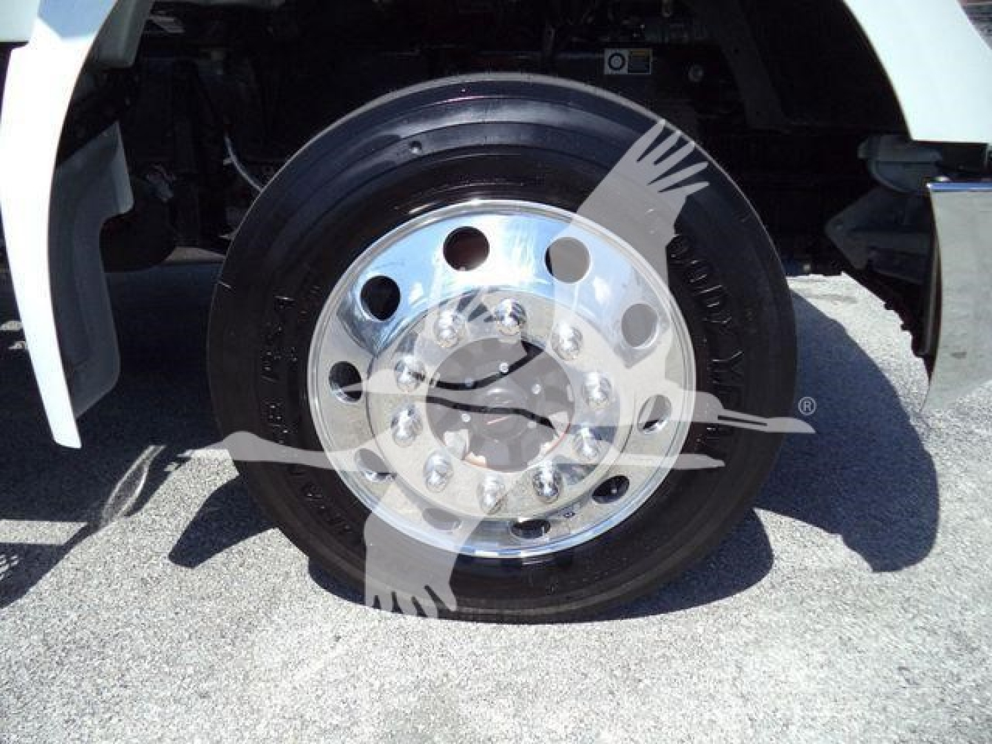 Truck wheel and chrome hub showing large round hub with multiple lug patterns on a Kenworth T280 rollback truck.