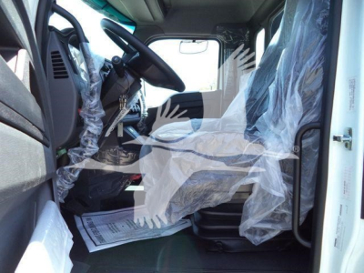 Kenworth T280 truck cab interior view with plastic seat covers and steering wheel; front seats and dashboard visible.
