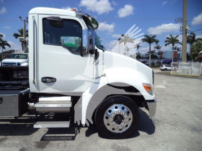 Truck side view showing white Kenworth cab, step ladder, large front wheel, and side door; no visible decals or text readable on image.