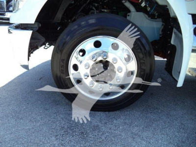 Kenworth T280 wheel and front suspension showing chrome wheel with lug nuts and tire, part of a rollback truck.