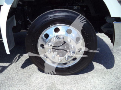 Truck wheel and chrome hub showing large round hub with multiple lug patterns on a Kenworth T280 rollback truck.