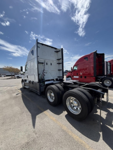 Freightliner Cascadia 126 truck trailer rear view showing 6-wheel dolly, grey cab, rear doors, and dual rear tires.