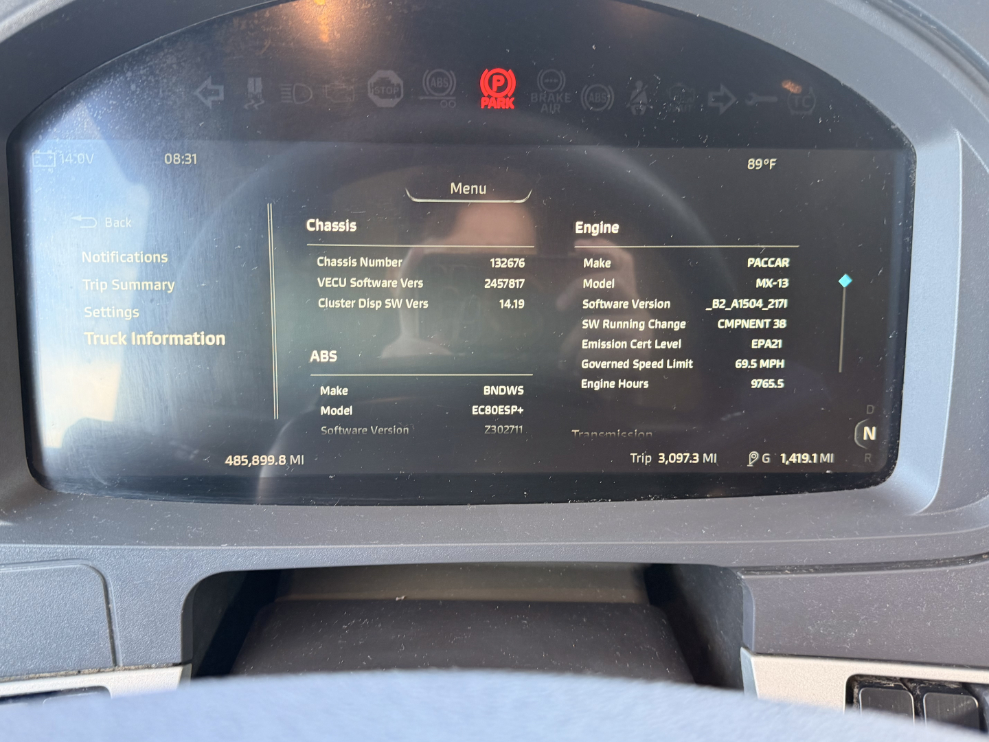 Kenworth T680 dashboard display showing vehicle information; chassis, engine, and ABS details on screen with menu options visible.