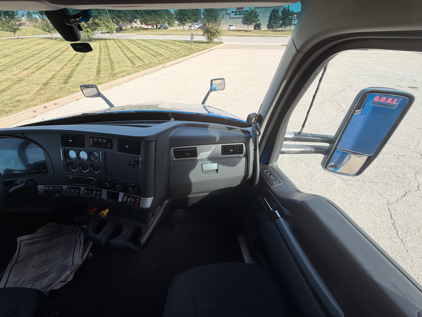 Kenworth T680 interior dashboard and driver-side window view from outside cab, with side mirror and windshield visible.