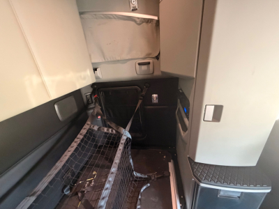 Kenworth T680 cab interior showing entry area and storage with carpeted floor and side panels.