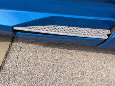 Kenworth T680 side step and blue truck body with textured chrome running board.