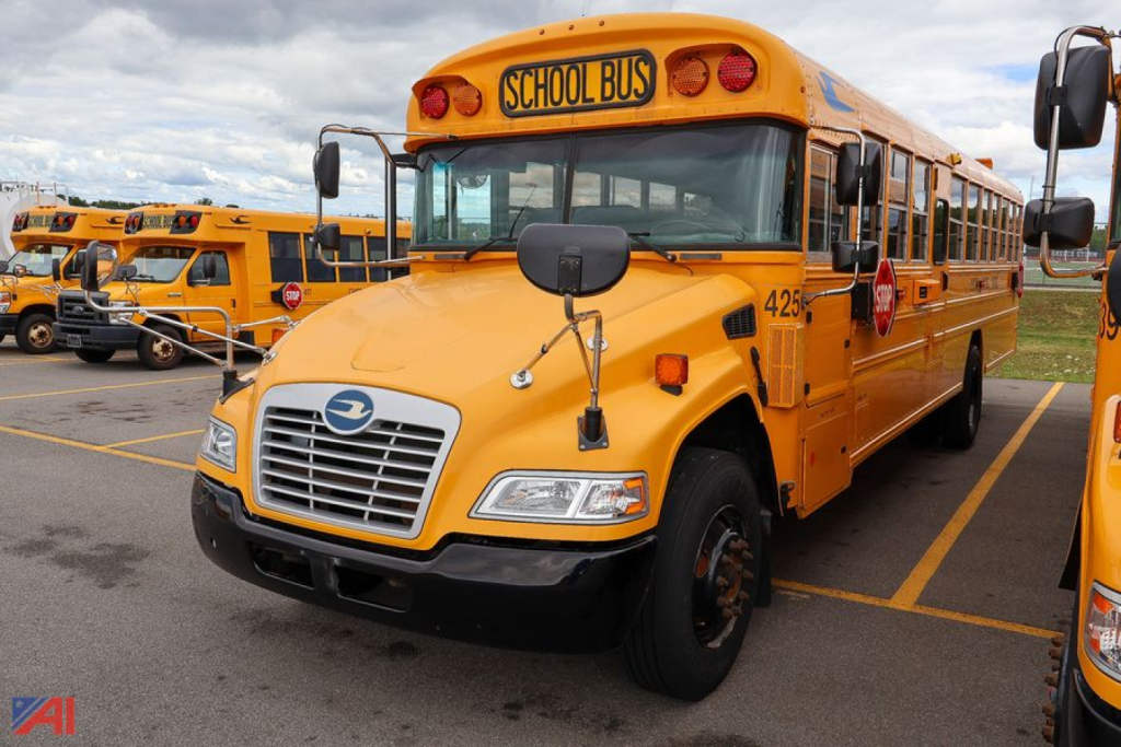 School bus showing front and side, yellow color, 'SCHOOL BUS' sign on top, blue bird logo on grille, headlights, mirrors, and bus number 425 visible.