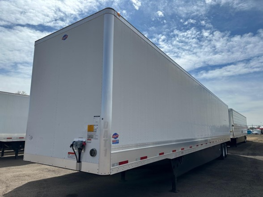 Utility trailer 4000Dx side view showing front nose with hitch and rear wheels, white aluminum exterior, mid-body decals.