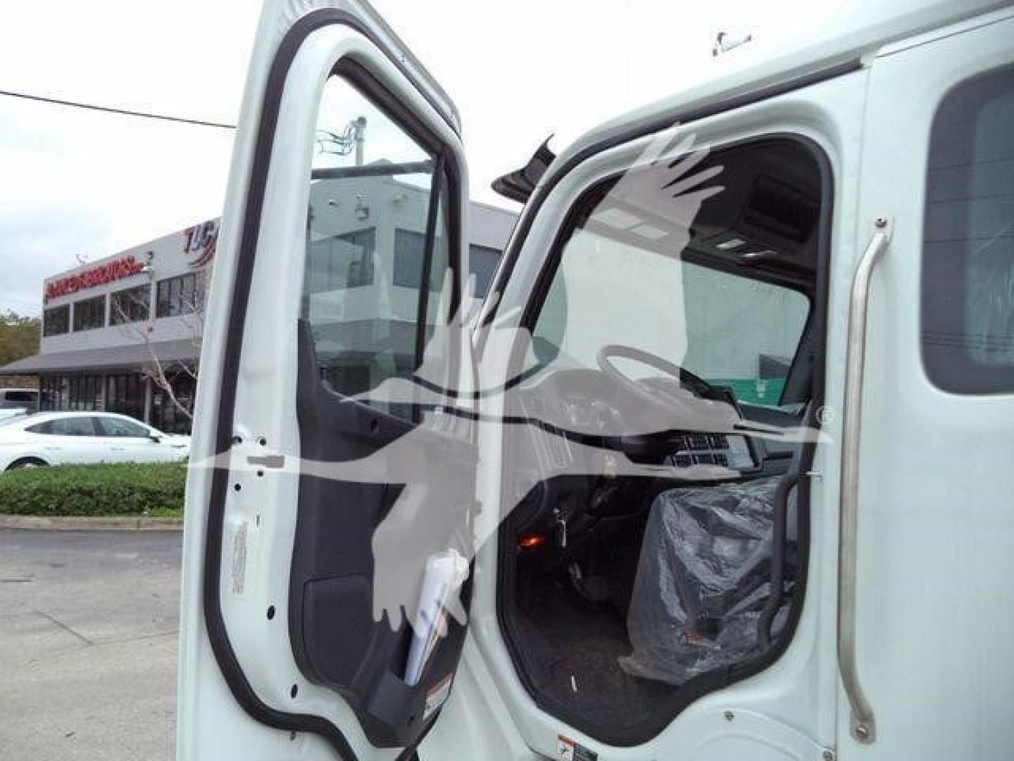Cab opening of a Freightliner M2 106 truck showing interior door area and open passenger door.