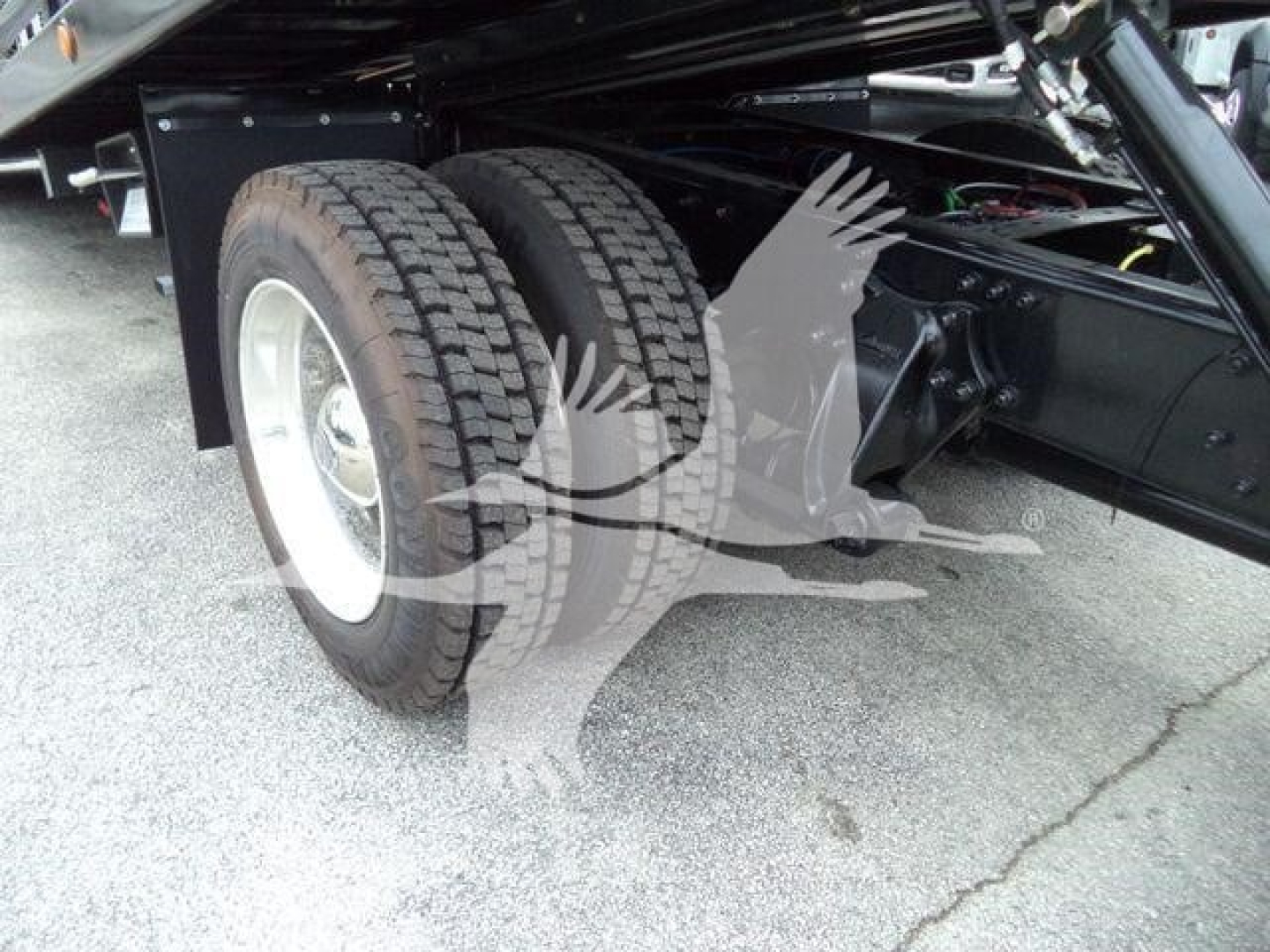 Freightliner M2 106 roll-back truck dual rear wheels and suspension view showing tires and chassis components.