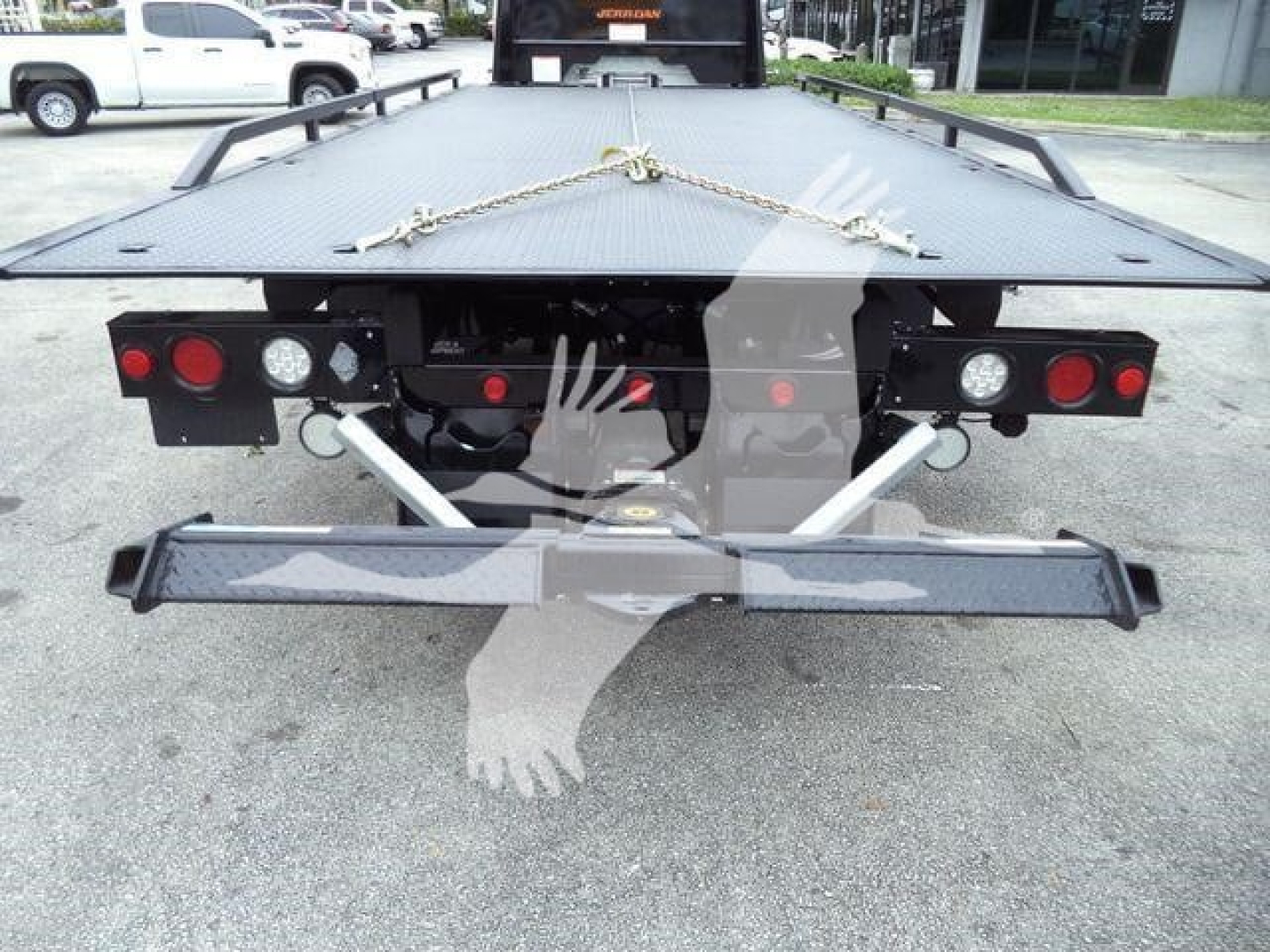 Freightliner M2 106 rollback bed rear view showing tail lights, bumper, and tie-down chains.