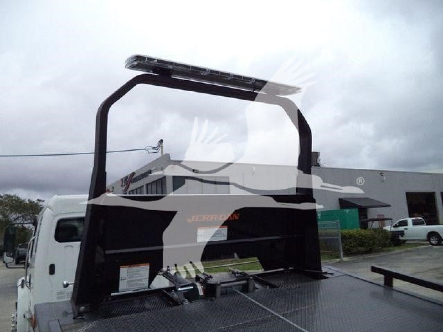 Freightliner M2 106 rollback truck bed with hydraulic lift and rear rack visible.