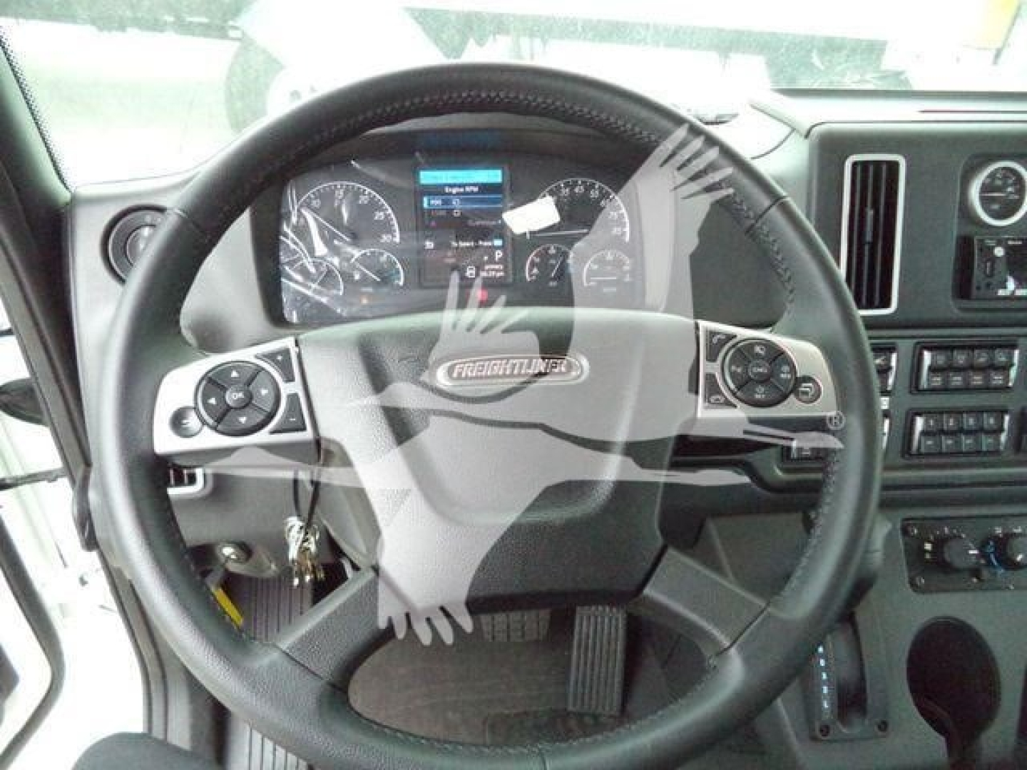 Dashboard and steering wheel of a Freightliner M2 106 truck showing instrument cluster and steering wheel with Freightliner badge.