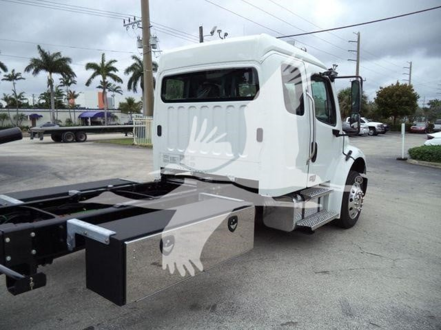 Truck cab and chassis of a 2027 Freightliner M2 106 rollback in white, side view showing cab, rear chassis, and side steps.