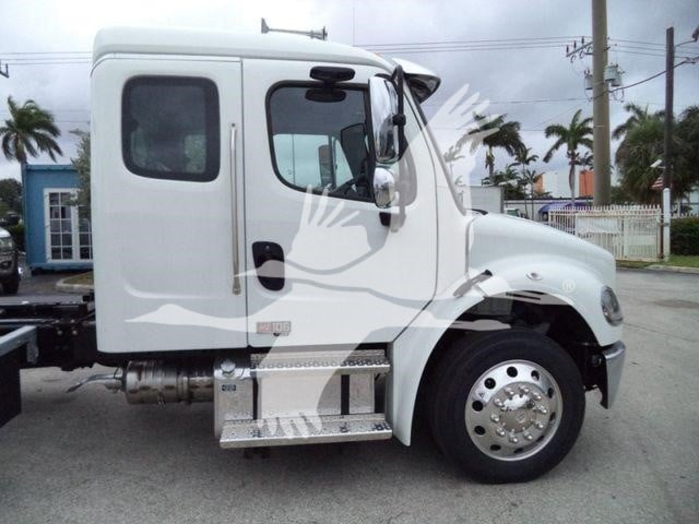Truck cab side profile showing Freightliner M2 106 with white paint, single cab, chrome fuel tank, aluminum side steps, wheel, and side mirror.