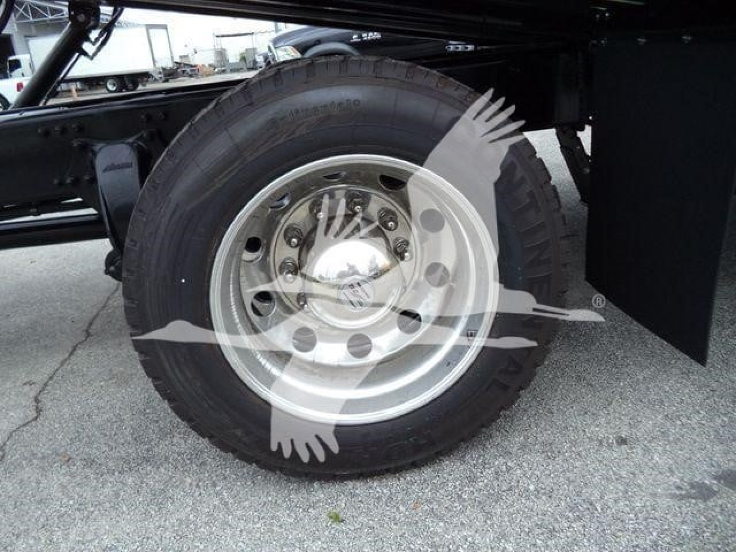 Truck wheel and dual rear axle from Freightliner M2 106 showing steel rim and tire with wheel cover and chassis frame