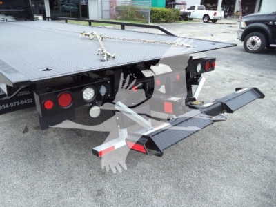 Freightliner M2 106 rollback truck rear with flatbed and hydraulic ramps showing platform and bumper area.