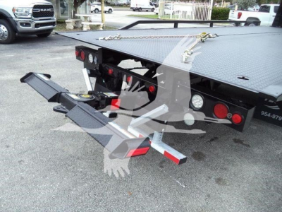 Freightliner M2 106 rollback truck rear with hydraulic tilt bed and chain latching, visible tail lights, and rear bumper steps.