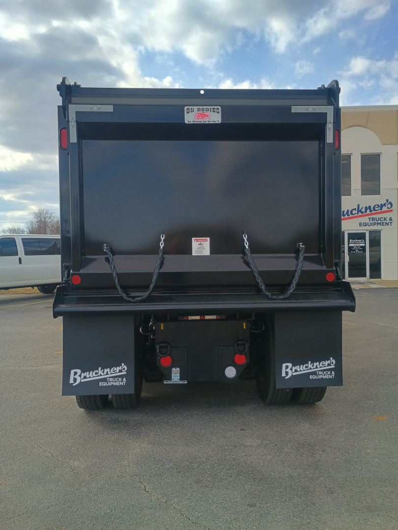 Dump truck bed rear view of a 2026 Mack GR84F showing dump body, taillights, and hydraulic chains. Visible branding: Buckeye's Equipment mud flaps.