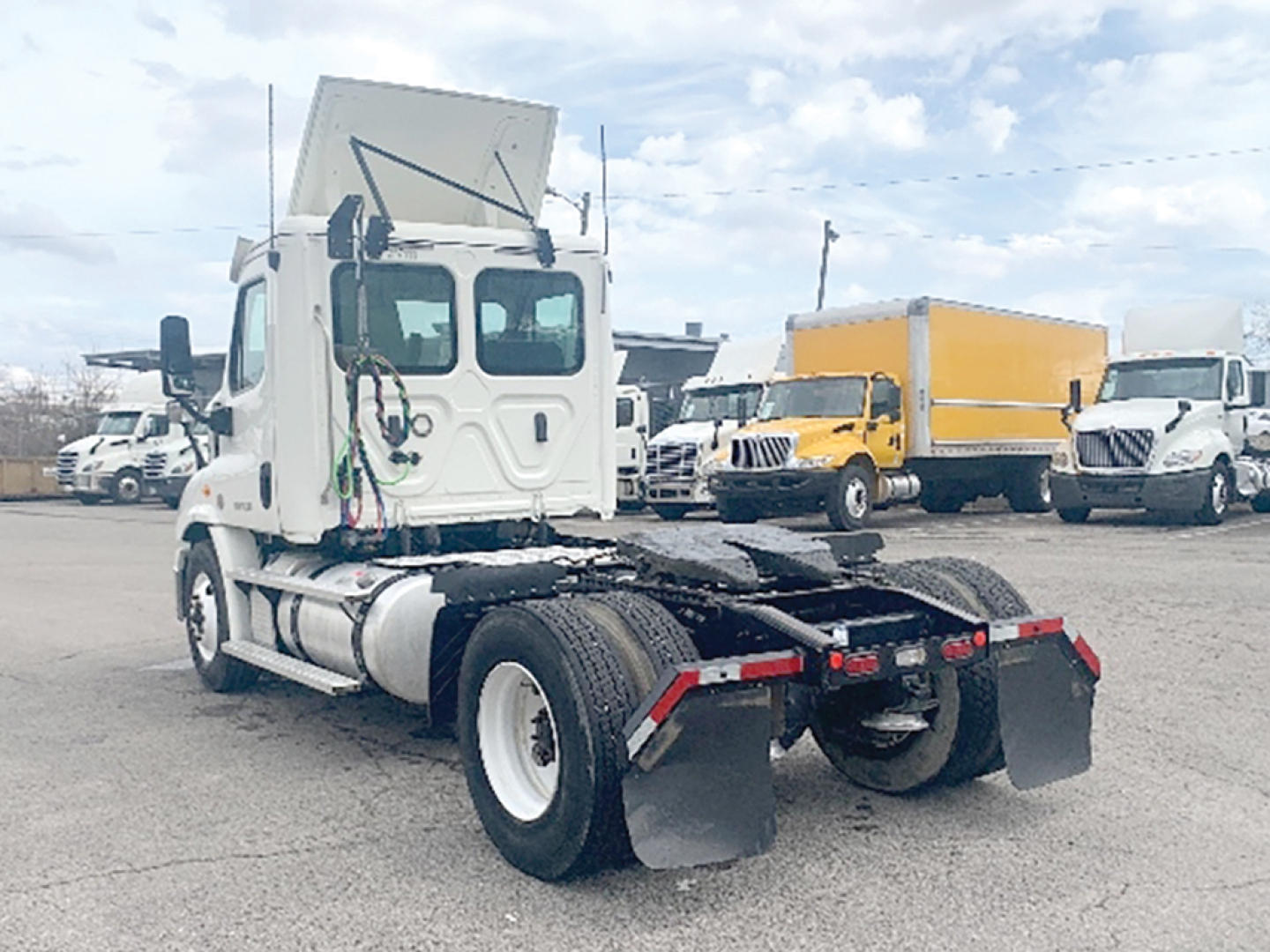 Truck chassis rear view of a 2019 Freightliner Cascadia113 daycab with dual rear axles and mud flaps.
