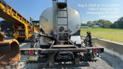 Back view of a white GMC ACL distributor truck with a large cylindrical tank and hitch, showing rear lights, bumper, and license plate. Overlay text shows date, time, and location in Washington PA.