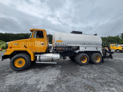 GMC ACL distributor truck in orange with a large cylindrical tank, side profile view showing front cab and dual rear axles.