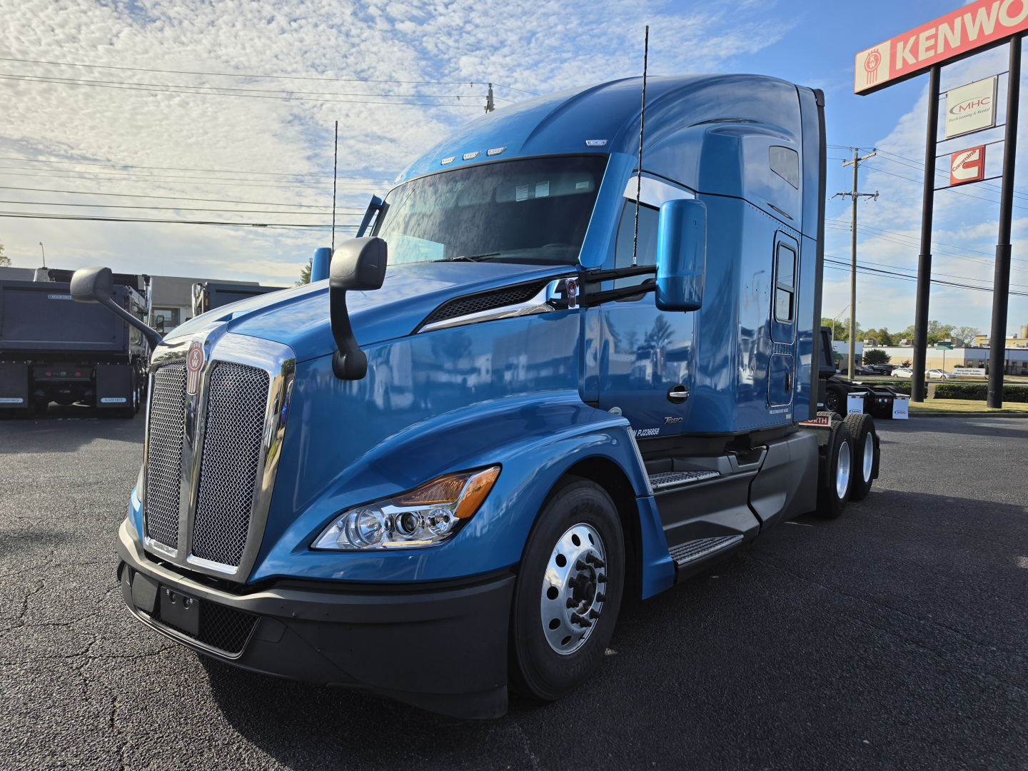 Kenworth T680 truck in blue, side view showing cab with large grille, aerodynamic mirrors, and sleeper configuration.