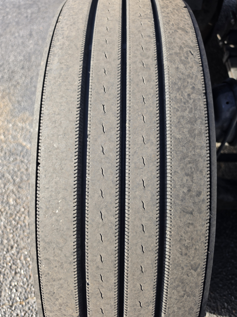 Kenworth T680 wheel/tire close-up showing tread pattern and sidewall details.