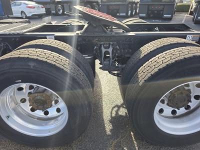 Kenworth T680 chassis showing tandem rear axles and frame rails with fifth wheel and air/electrical lines visible.