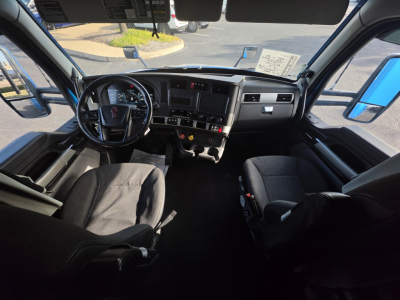 Kenworth T680 truck interior showing steering wheel, dashboard, and front seats from driver’s perspective.