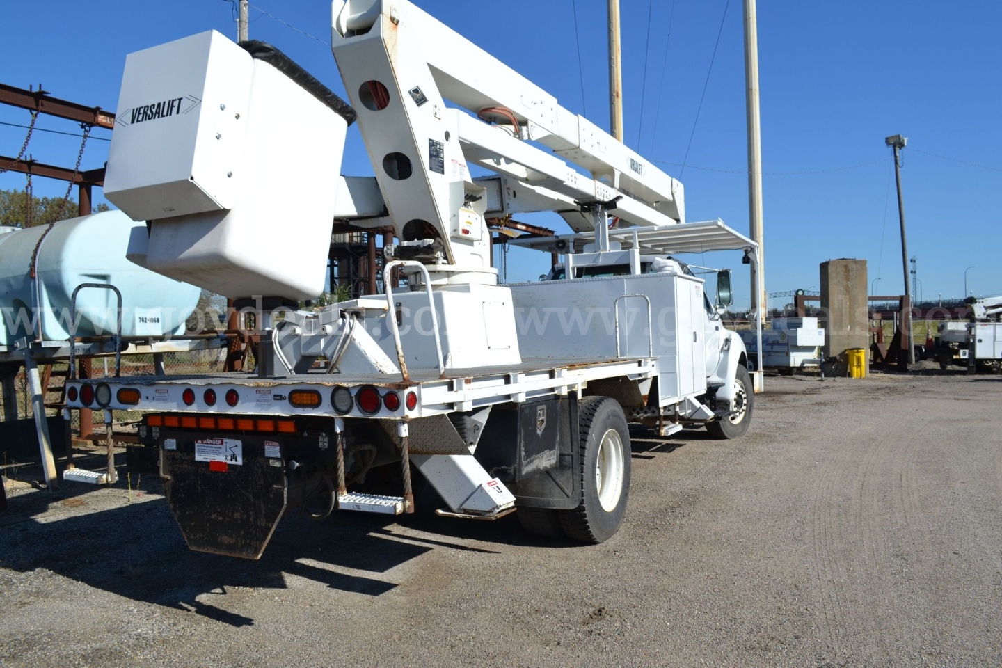 2008 Ford F-750 bucket truck with boom lift, rear view showing Titan/Mab equipment, multiple taillights, and work truck chassis.