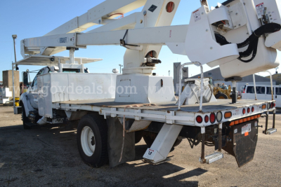 Ford F-750 bucket truck with raised aerial lift on a flatbed, rear view showing boom and stabilizers.