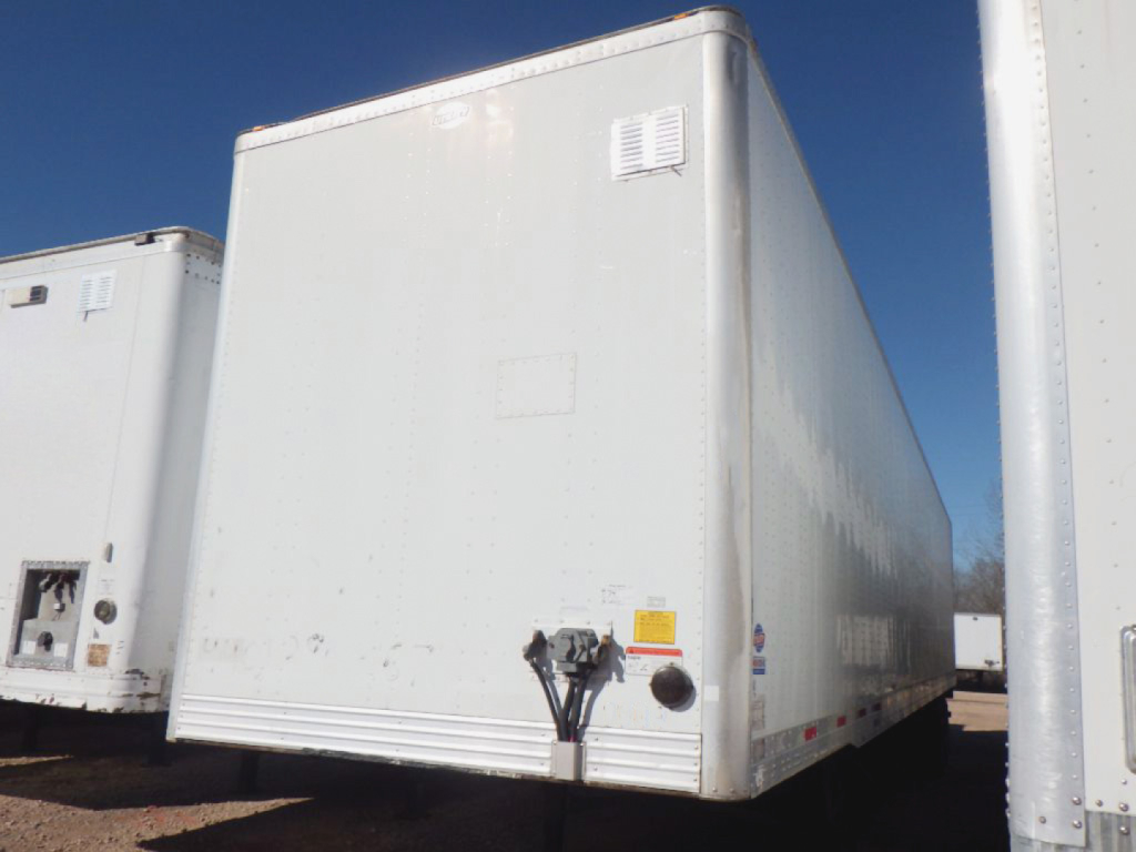 Utility trailer 4000D-X side/front view showing exterior with a vent and rear doors. Weathered white aluminum box trailer.