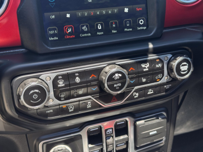 Jeep Gladiator dash controls with climate and media touchscreen visible, central control knobs and buttons