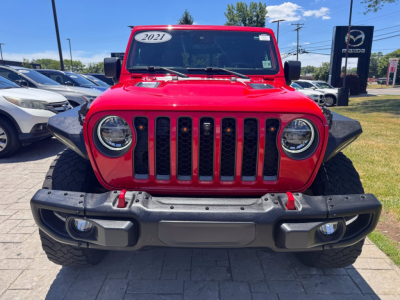 Front view of red 2021 Jeep Gladiator showing grille, round headlights, and bumper.