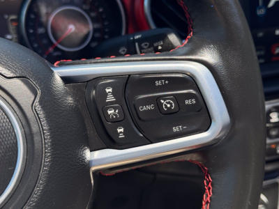 Jeep Gladiator steering wheel controls and dashboard; cruise control and multitool buttons visible on right side of wheel.