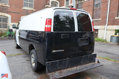 Chevrolet Express cargo van rear view showing police conversion with large steel rear bumper and dual color black/white paint