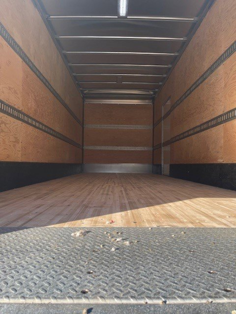 Box van truck interior showing empty cargo area with wood sidewalls and metal reinforced rails