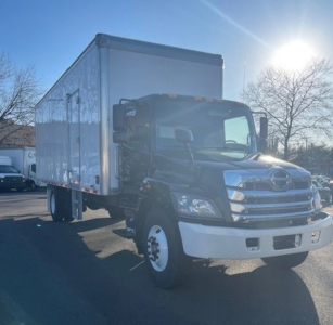 Hino L6 box truck viewed from front-right, showing cab and large cargo box in daylight.