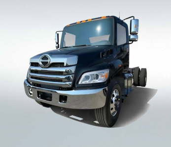 Truck cab showing Hino-style front grille with chrome bumper and side mirrors; blue box van truck silhouette.