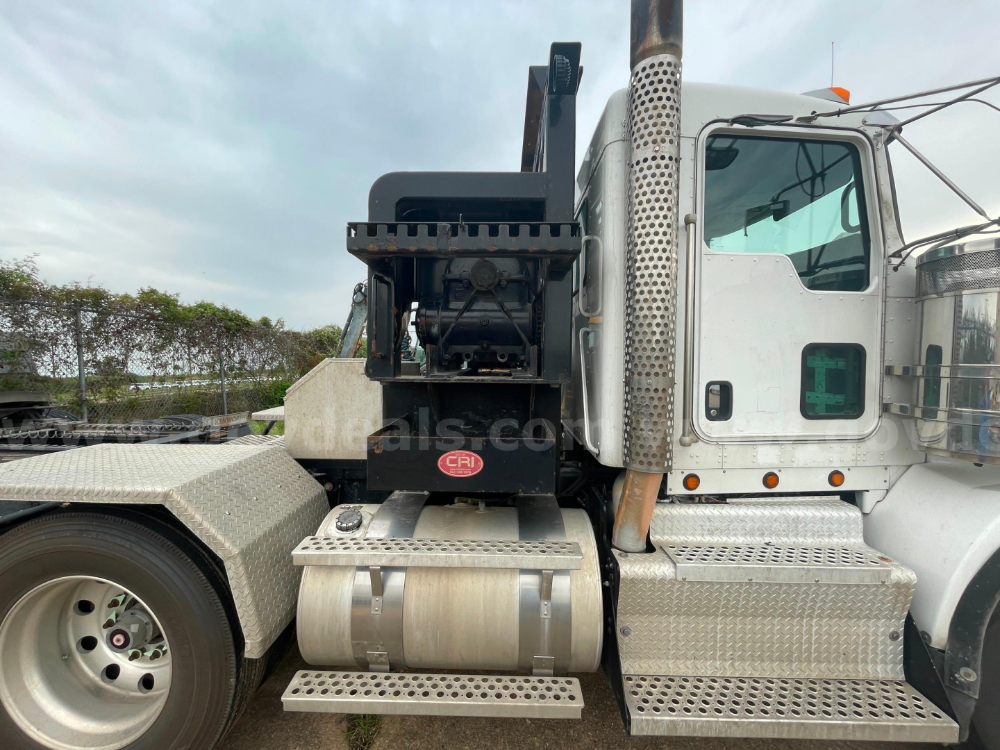 Kenworth T800 side view showing diesel exhaust stack, fuel tanks, steps, and crane attachment with KR label.