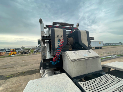 Kenworth T800 truck chassis with take-up winch and coiled red air line, metal platform, and toolbox visible from rear/side angle.
