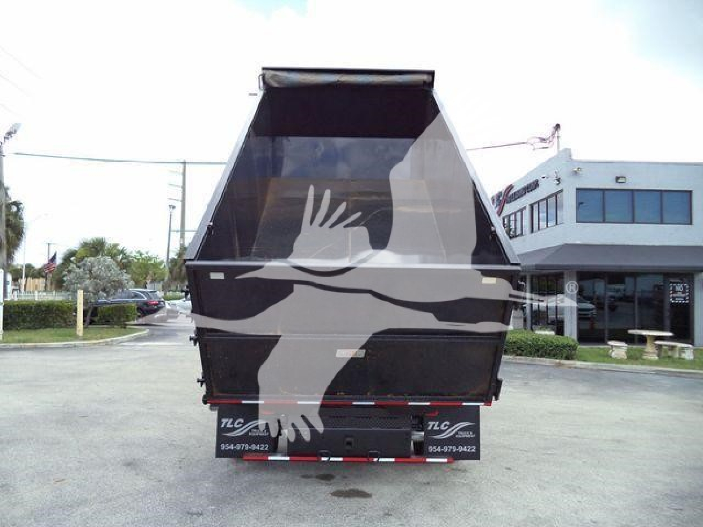 Dump truck bed of a 2011 Ford E450 rear view showing open-top dump box and tailgate with TLC branding.