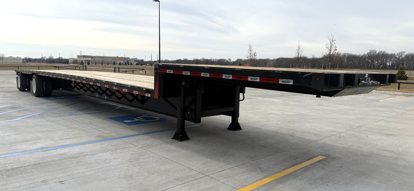 Trailer image showing a 53' drop deck spread trailer with black frame and landing gear in a parking lot.
